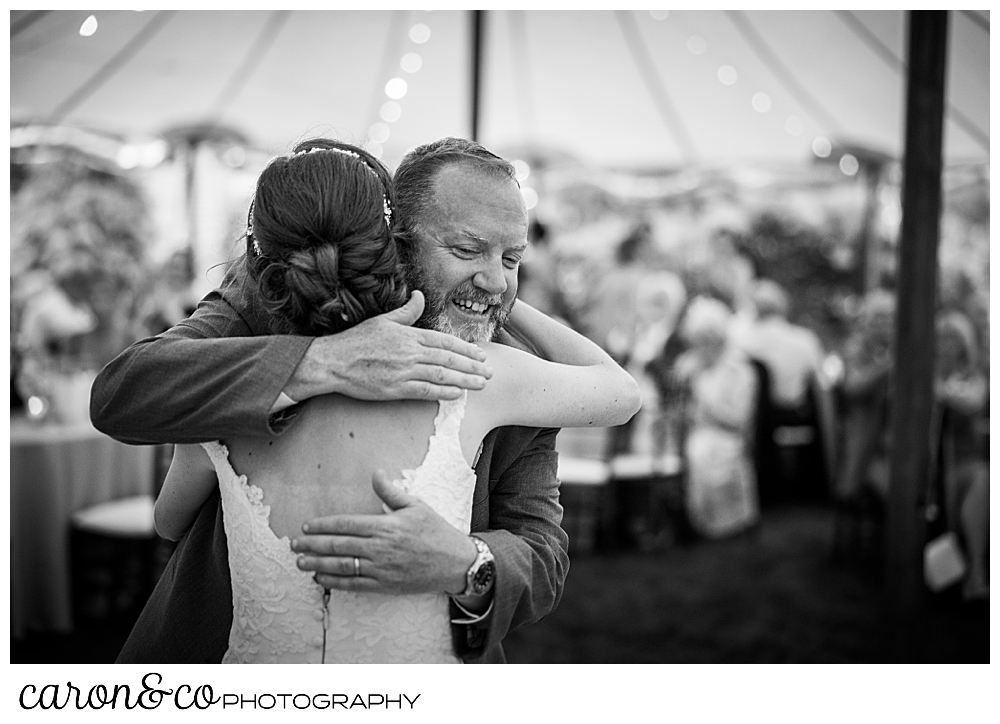 black and white photo of a bride hugging her father after the father daughter dance, at a Kennebunk Maine wedding reception