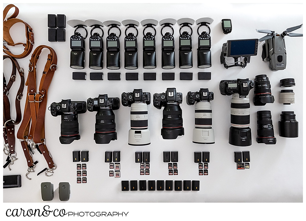 a collection of Maine wedding photography gear, cameras and lenses by Canon, Godox flashes, CF and SD cards, batteries, drone, and camera straps that caron&co photography use as coastal Maine wedding photographers