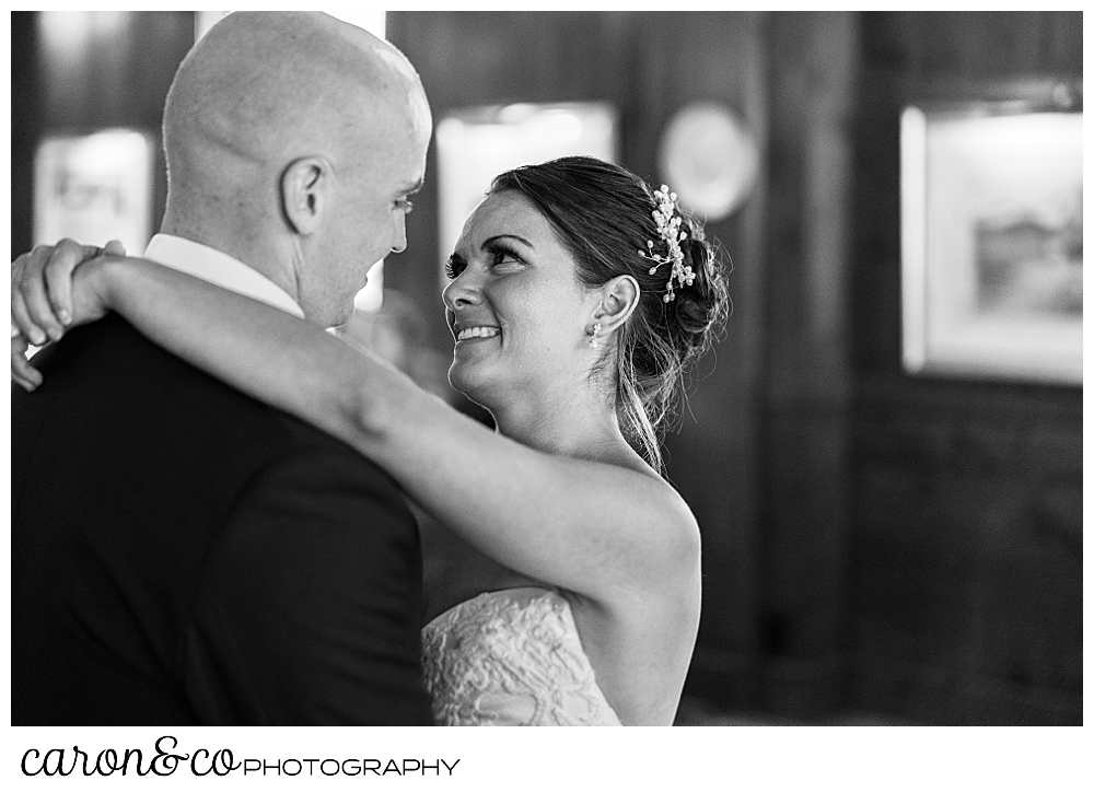 black and white photo of a bride smiling at her groom during their first dance at a Kennebunkport wedding at the Colony Hotel