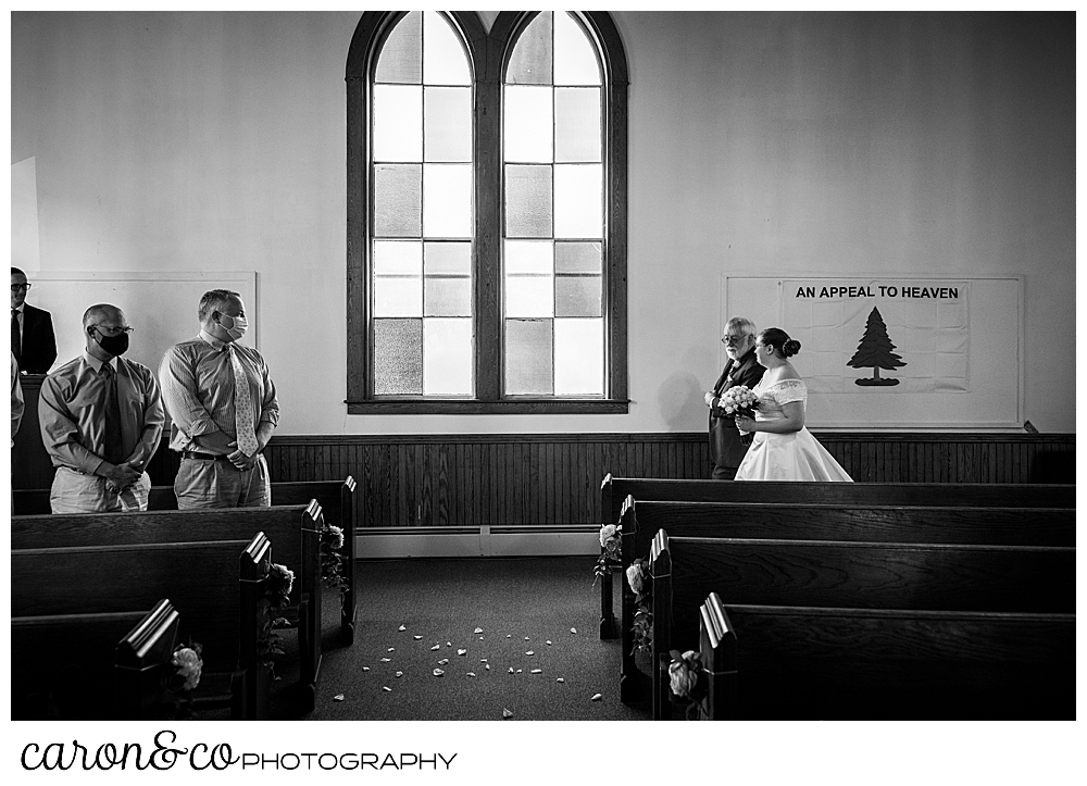 black and white photo of a bride and her father approaching the aisle in the Peru Maine Baptist Church