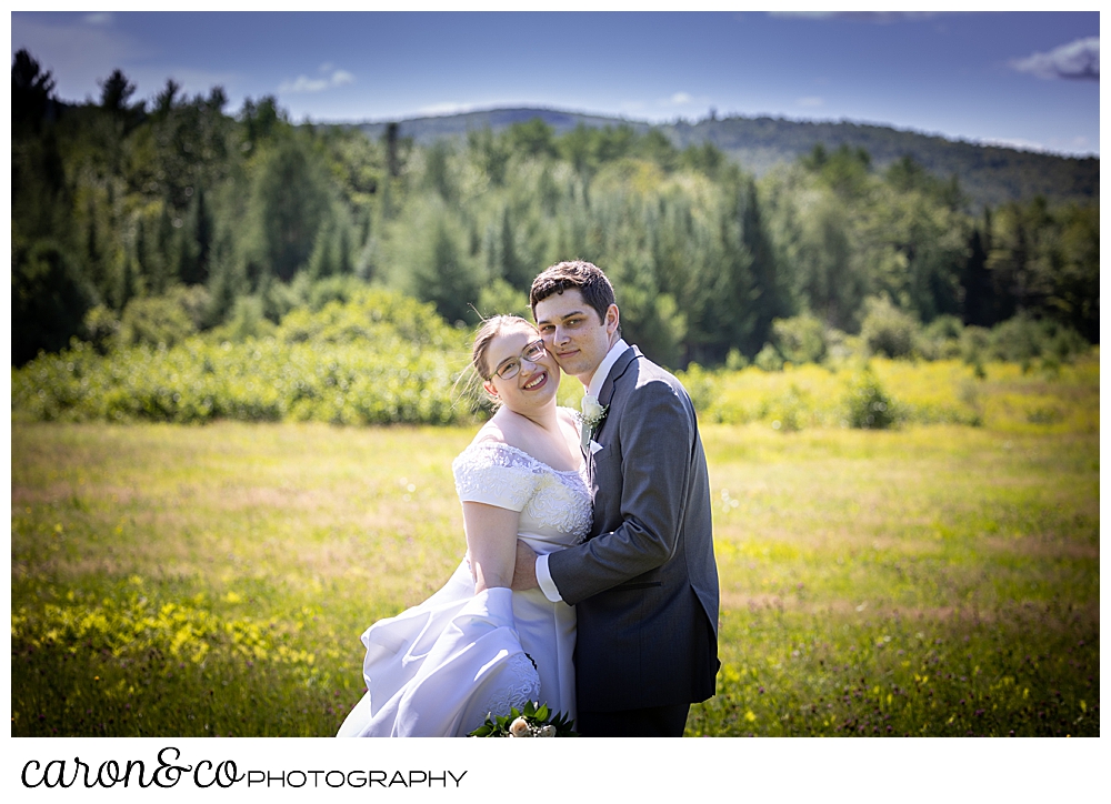 bride and groom portrait in a field in the mountains of western maine