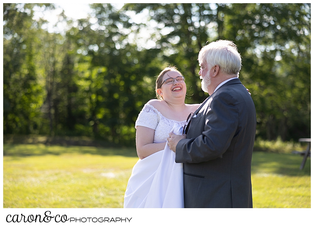 a bride and her father dance the father daughter dance in a field