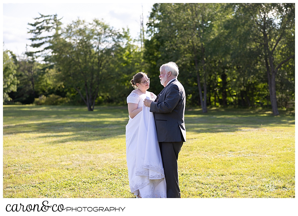 a bride and her father dance in a field during a sweet western Maine wedding reception