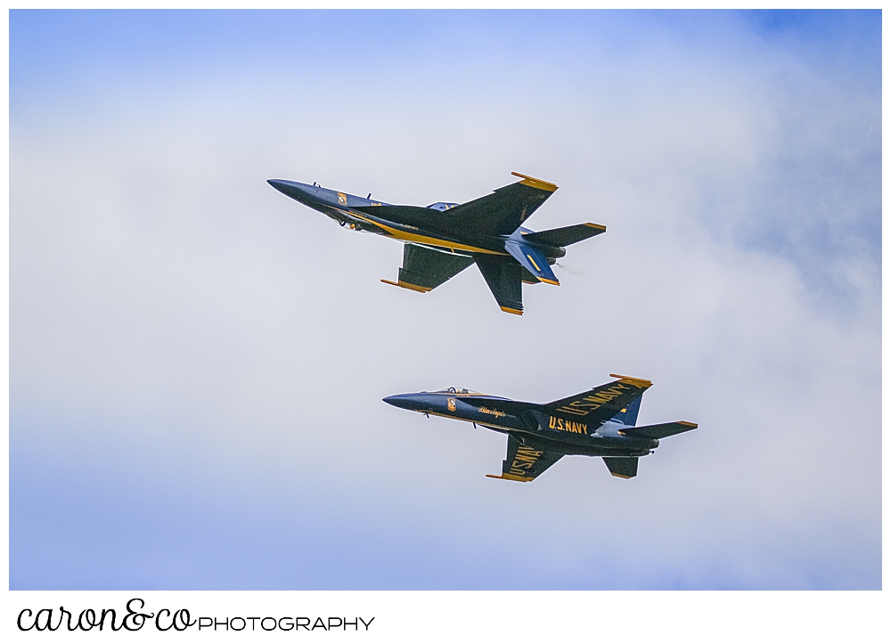 2 navy blue angels flying side by side one of them is flying upside down