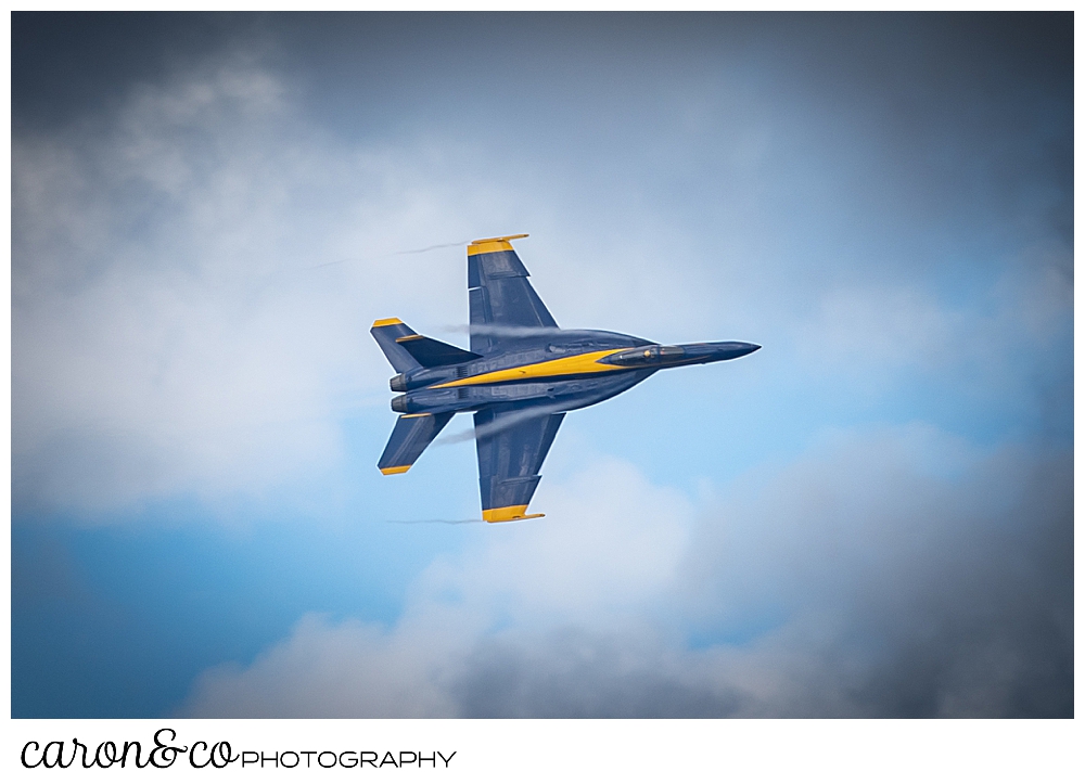 a single us navy blue angel flies through the cloudy skies over Brunswick, Maine