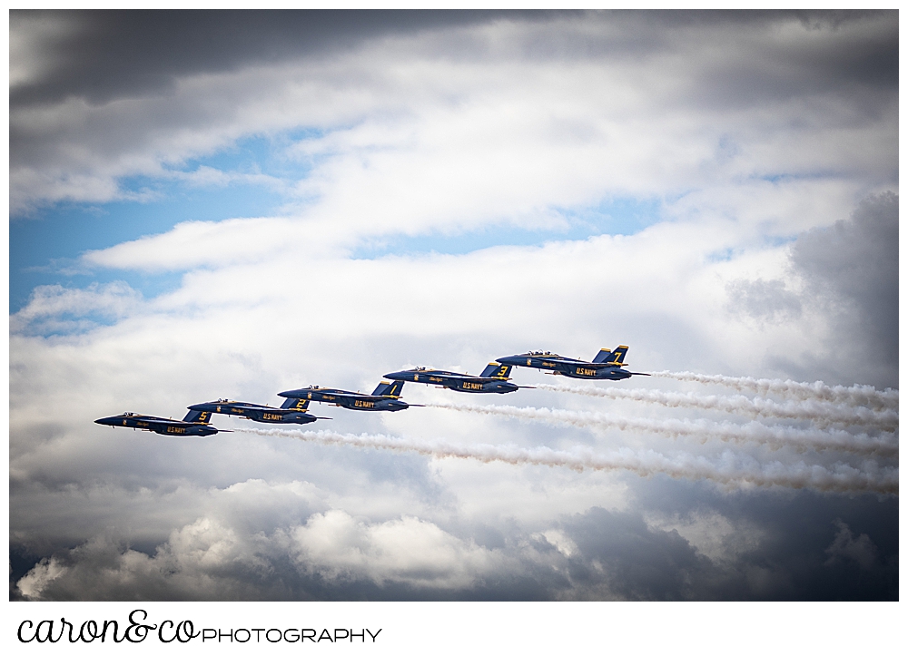 5 us navy blue angels fly together in a wavy pattern