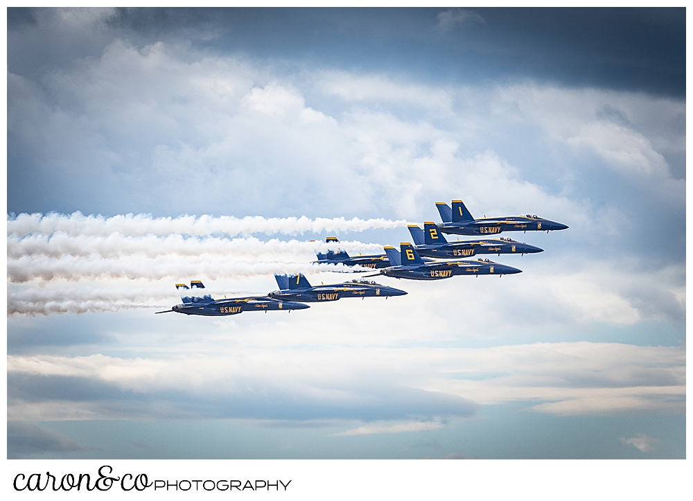 5 us navy blue angels flying side by side among the clouds over Brunswick maine