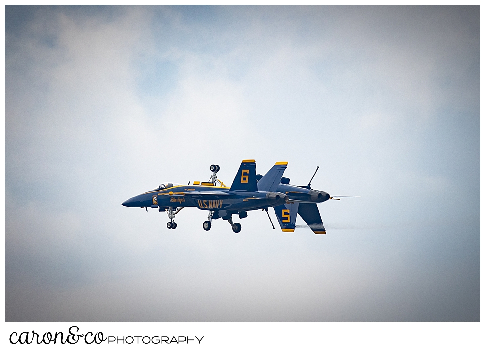 two us navy blue angels flying side by side, one of them upside down