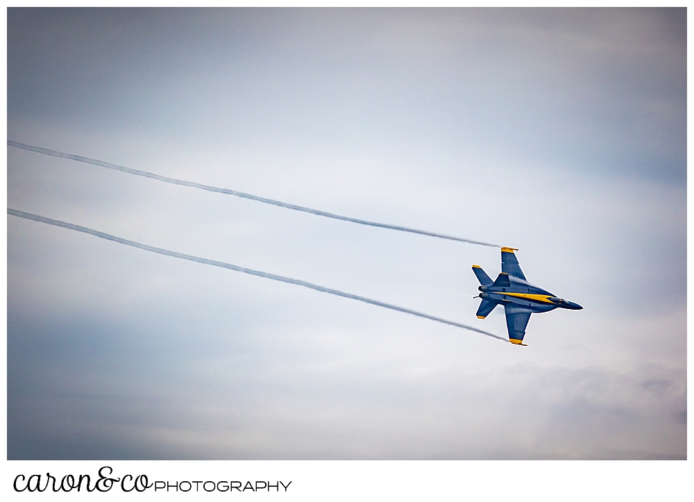 a us blue angel flies with two streams of exhaust