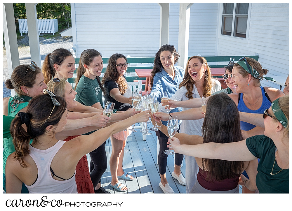 a group of young women reaching in the middle for a Champagne toast