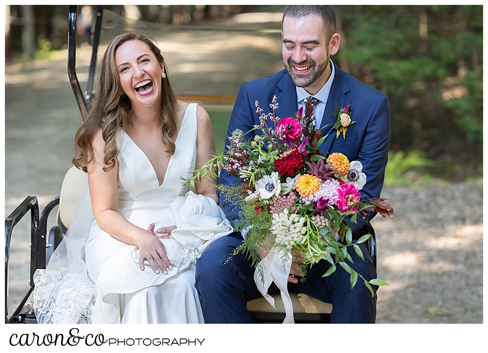 a bride and groom sit together on the back of a golf cart, the bride is laughing and the groom is smiling as he holds the bride's bouquet