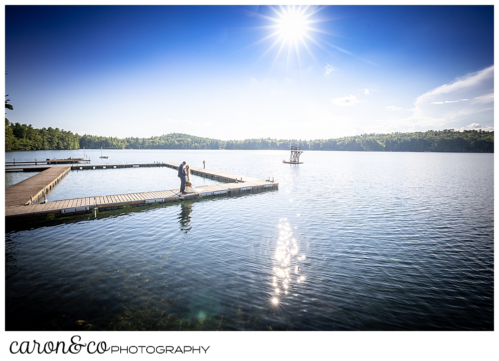 a bride and groom stand together on the dock at Camp Skylemar, Naples, Maine