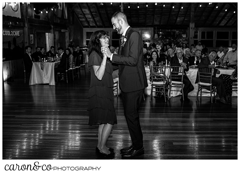 black and white photo of a groom dancing with his mother during the mother son dance