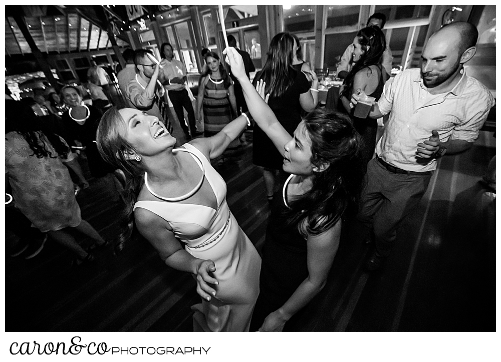 black and white photo of a bride dancing with a guest, they're both smiling