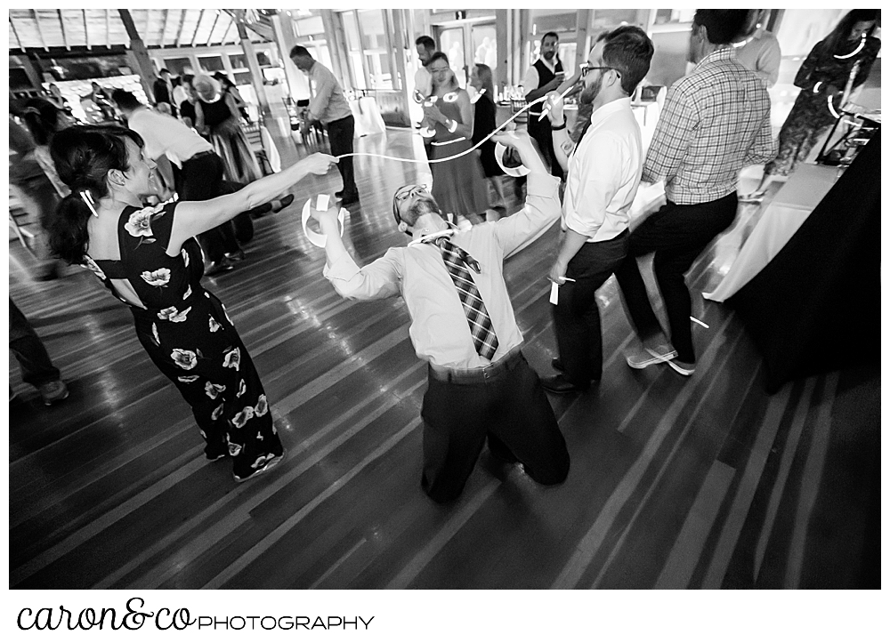 black and white photo of a groom doing the limbo