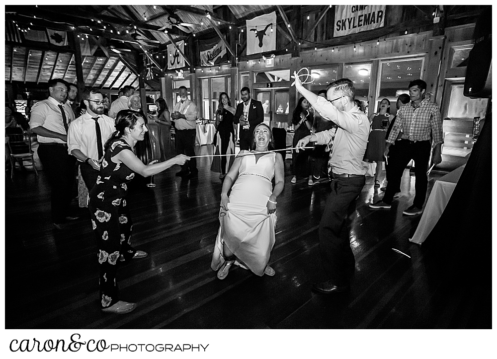 black and white photo of a bride doing the limbo