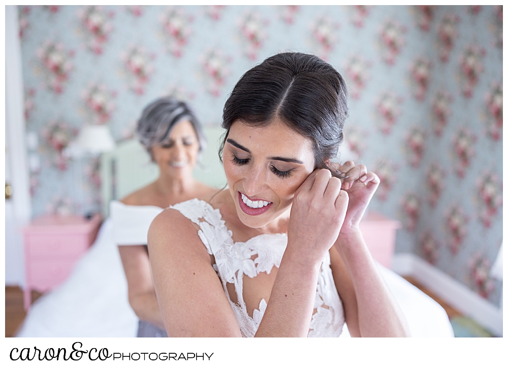 a dark haired bride, puts on an earring