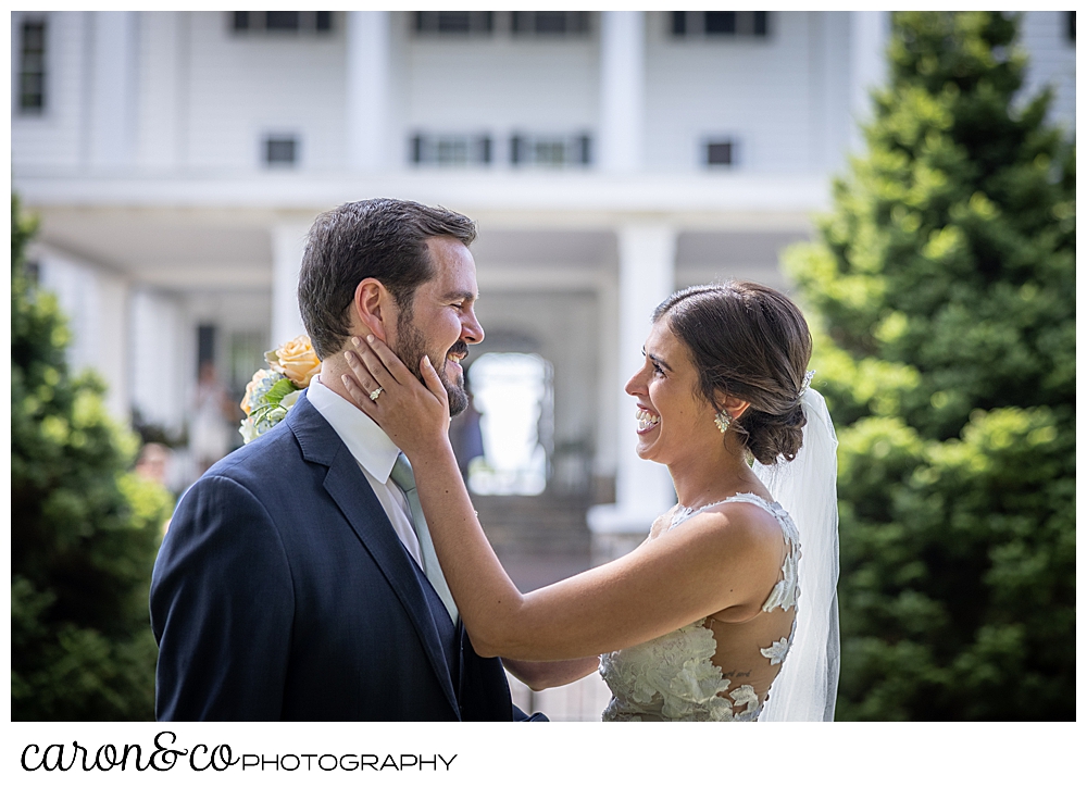 a dark-haired bride holds the face of her dark-haired groom during a Maine wedding day first look at the Colony Hotel Kennebunkport Maine