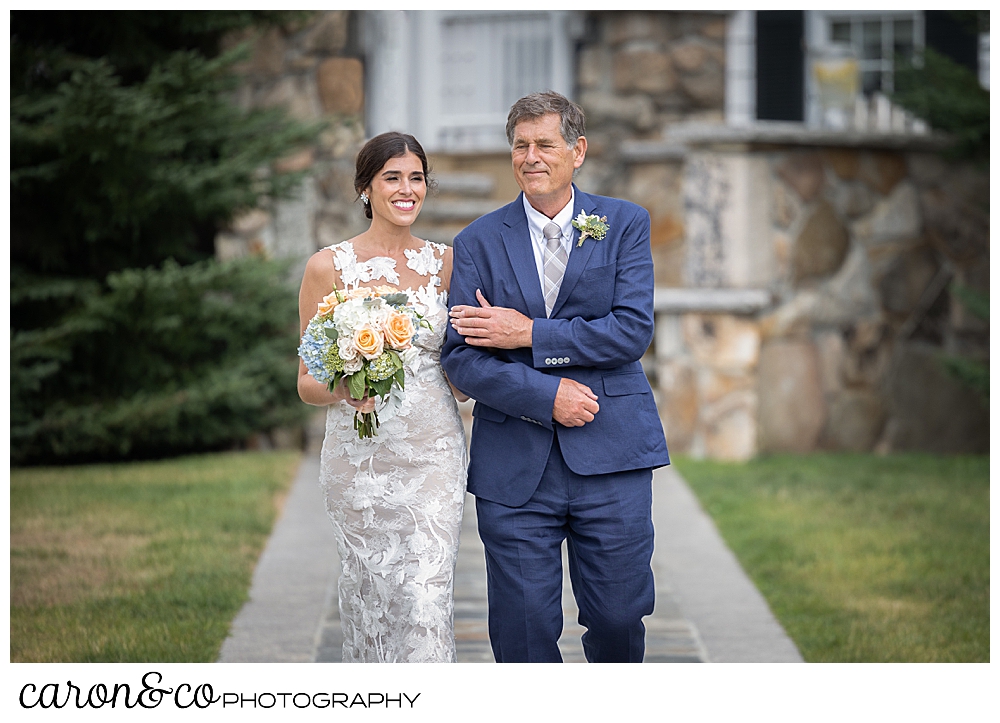 a bride and her father walk down the aisle at an outdoor wedding ceremony at the Colony Hotel, Kennebunkport, Maine