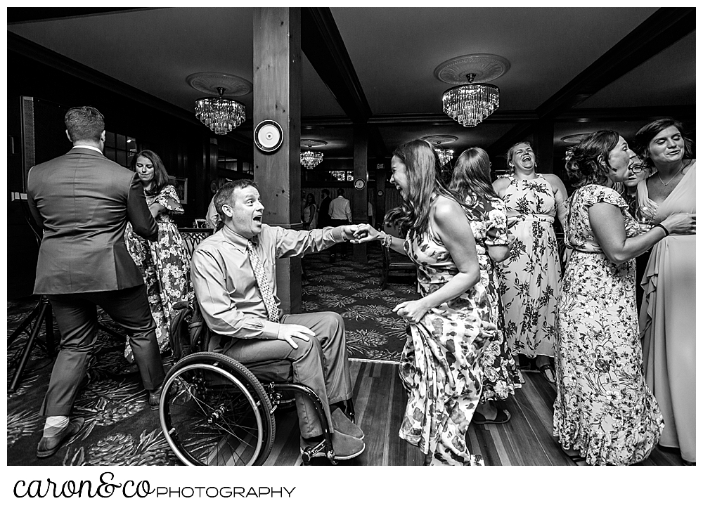 black and white photo of a man in a wheelchair and woman dancing at a wedding at the Colony Hotel