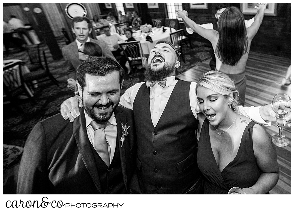 black and white photo of a groom dancing with wedding guests