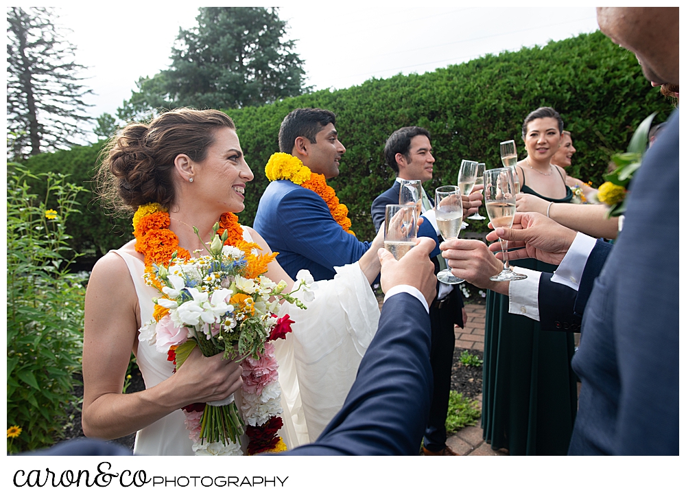 a bride and groom take part in a champagne toast after their recessional at a joyful Pineland Farms wedding ceremony