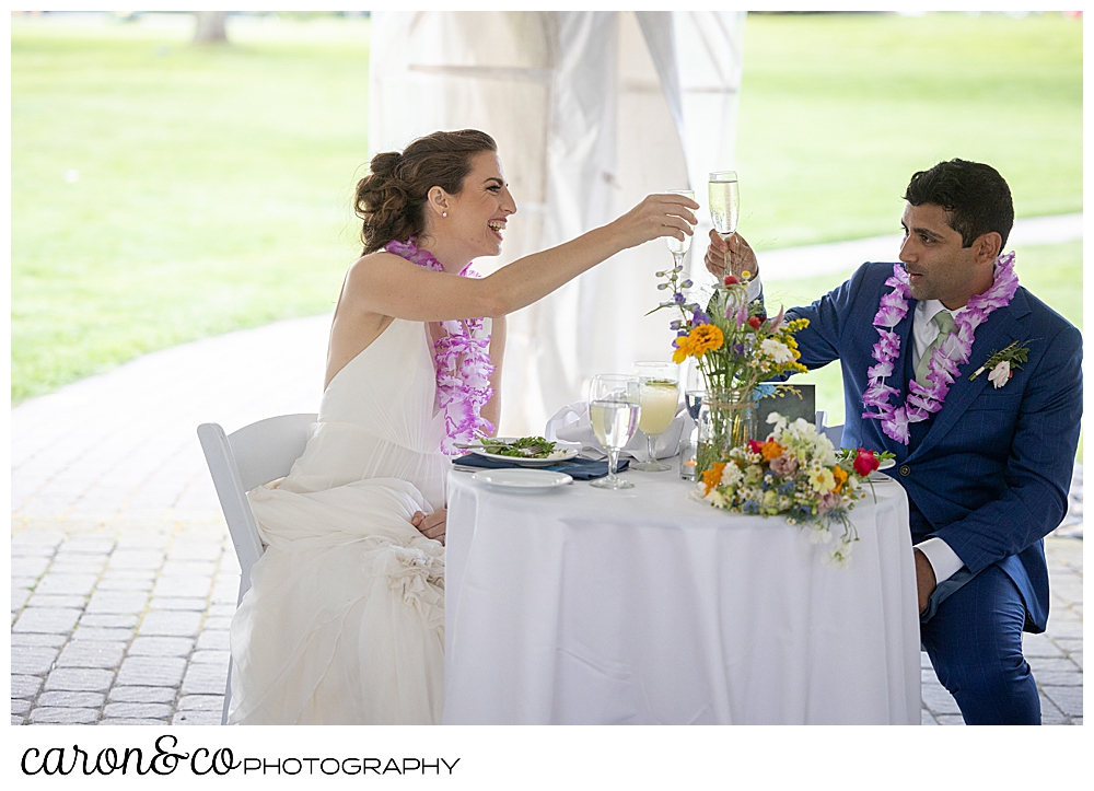 a bride and groom toast with champagne at their tented Pineland Farms wedding reception