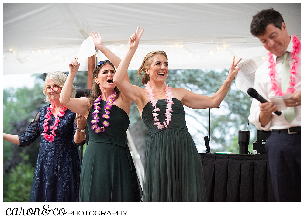 two bridesmaids, a bridesman, and a mother of the bride during wedding reception toasting