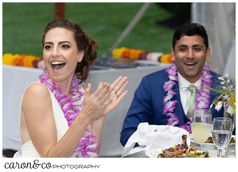 a bride claps, and a groom cheers during a Pineland Farms tented wedding reception