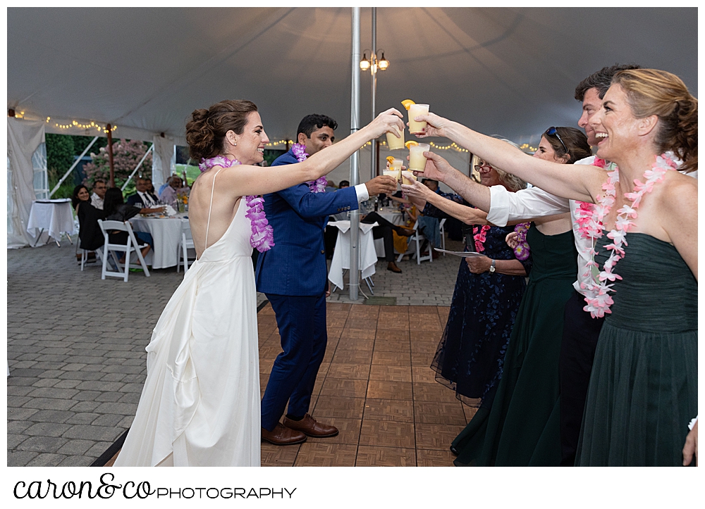 a bride and groom toast with the bride's sisters, mother, and brother