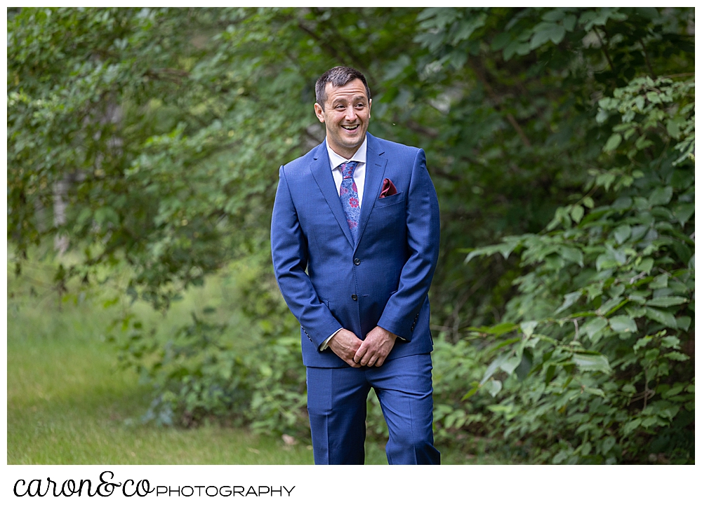 a groom wearing a blue suit, turns to see his bride during their Kingsley pines wedding day first look