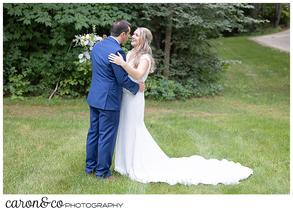 a bride and groom embrace during their wedding day first look at Kingsley Pines, Raymond, Maine