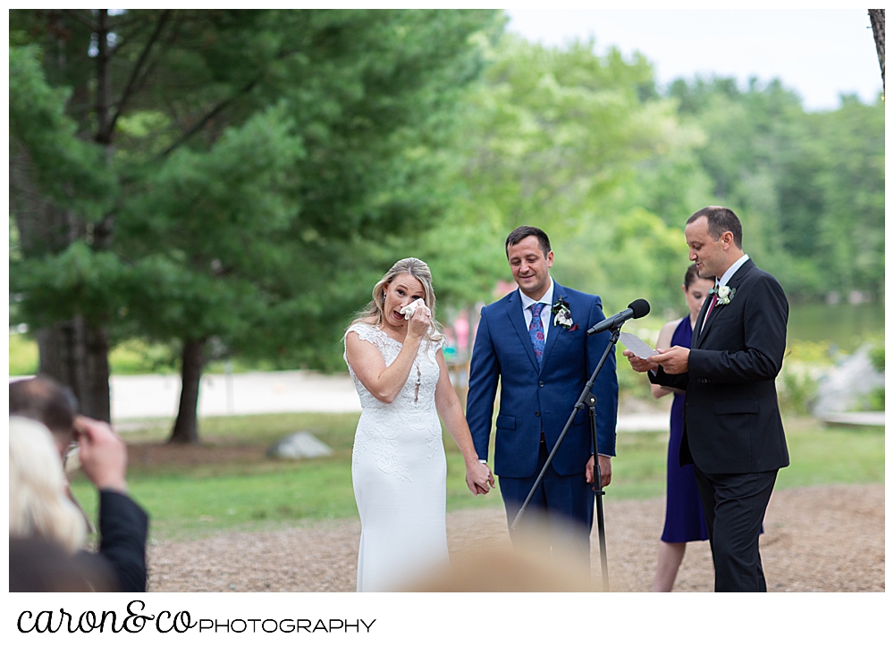 a bride wipes a tear away during a Kingsley Pines Maine wedding ceremony