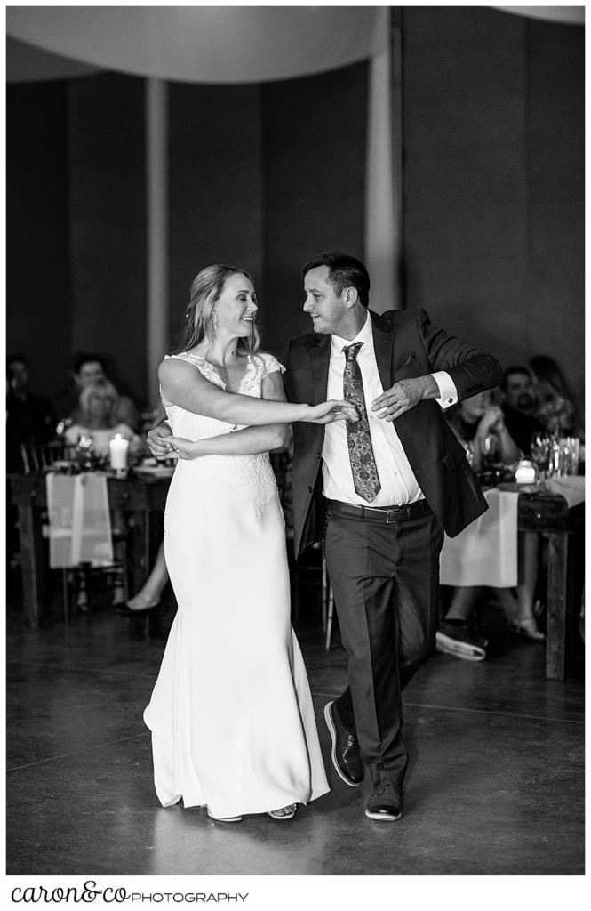 black and white photo of a bride and groom dancing side by side during their first dance
