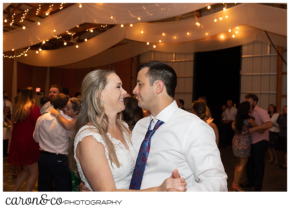 a bride and groom dancing their first dance at a Kingsley Pines Maine wedding reception