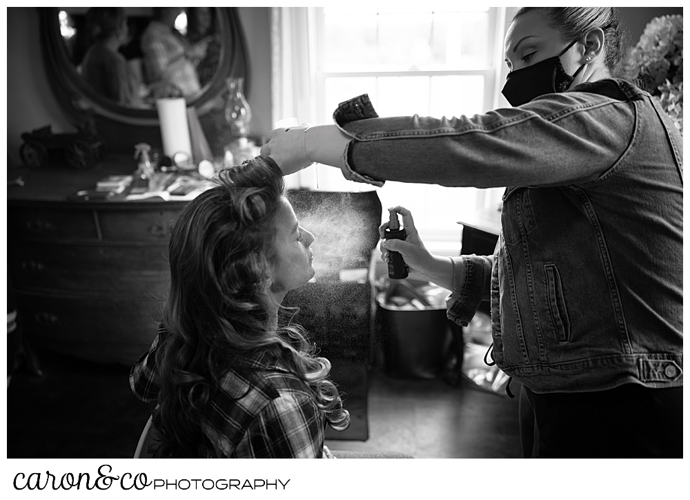 black and white photo of a bride having her face sprayed during makeup applicationmaine-wedding-barn-wedding