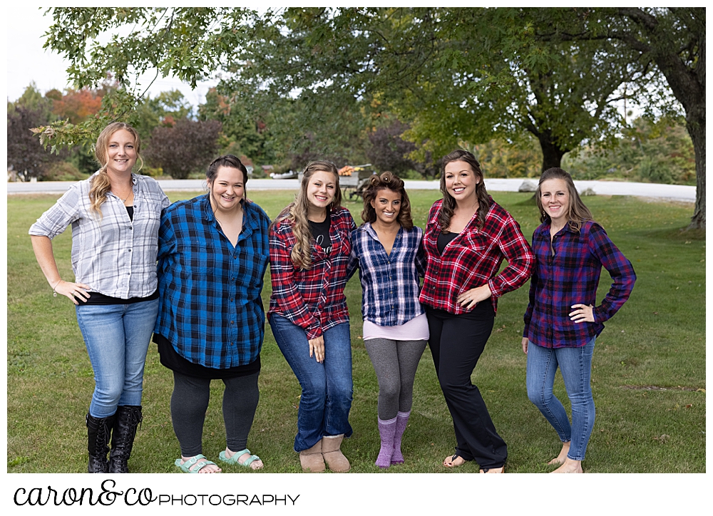 a bride and her bridesmaids wearing colorful plaid shirts before the ceremony