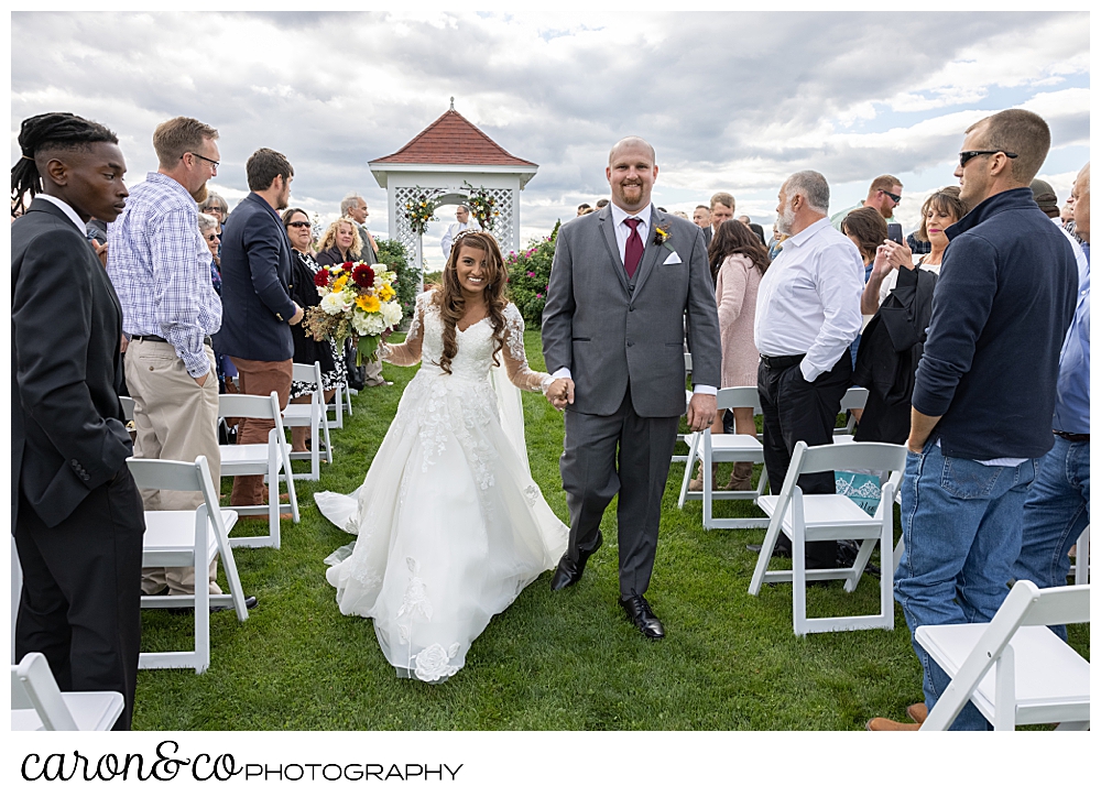 a bride and groom recess down the aisle at a wedding at Maine wedding barn in Minot Maine