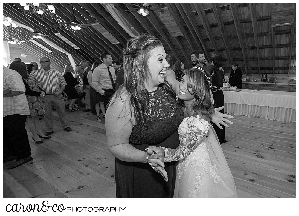 black and white photo of a bride dancing with a bridesmaid