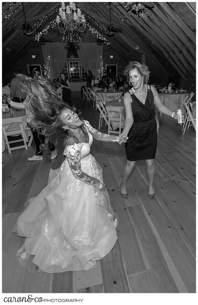 black and white photo of a bride dancing with a guest