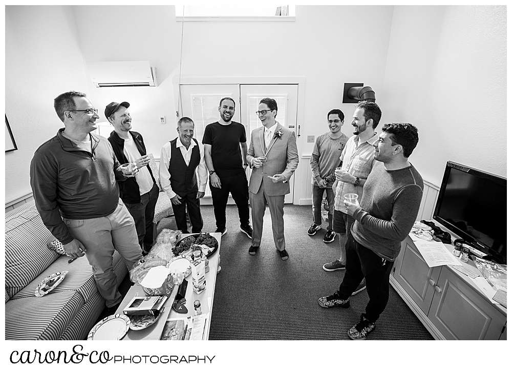 black and white photo of a groom in a suit, hanging out with his groomsmen
