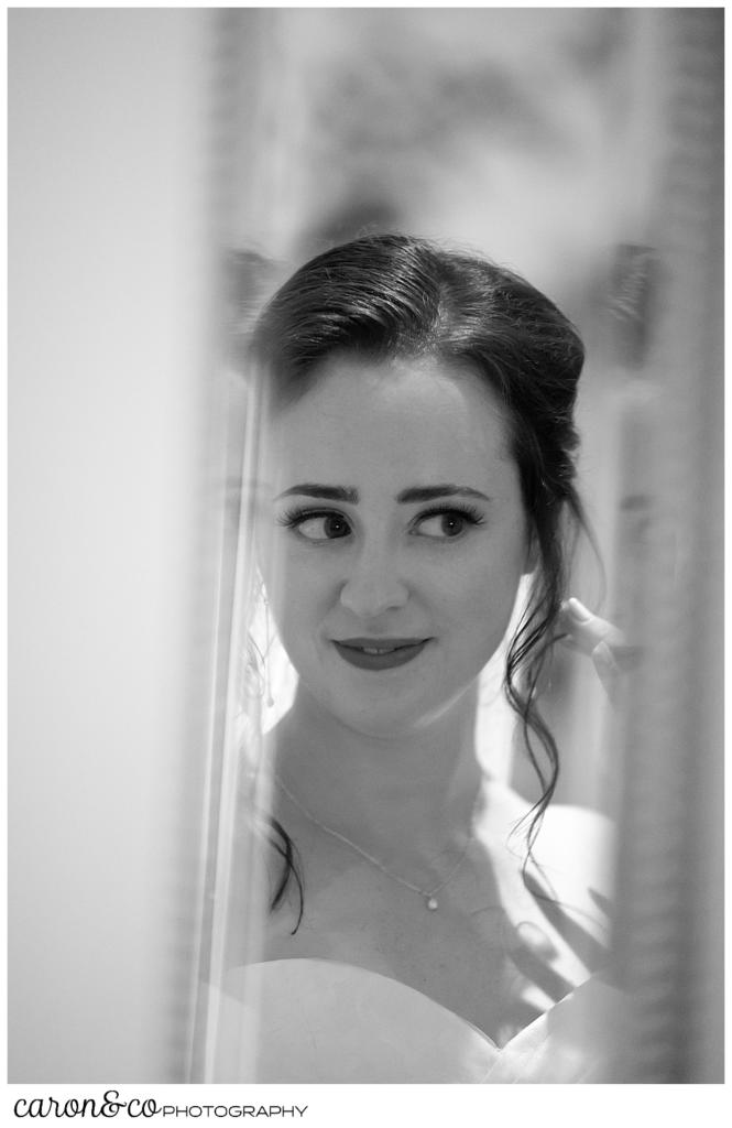 black and white photo of a bride looking in a mirror