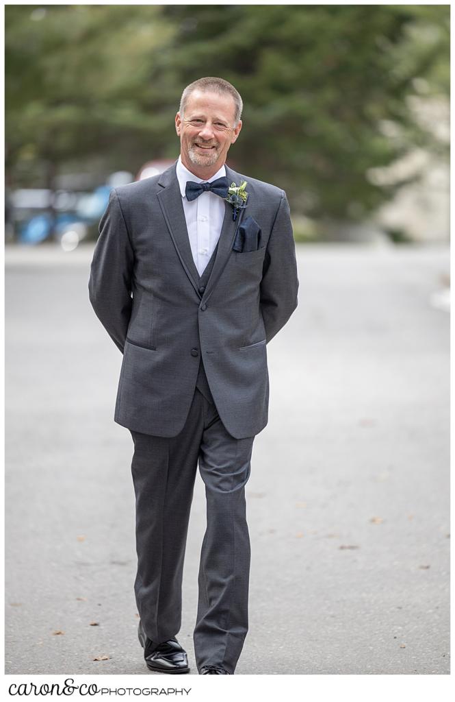 a father in a gray suit, approaches his daughter during a first look