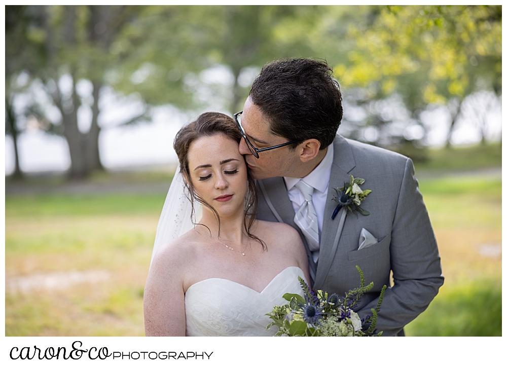 a groom kisses the cheek of his bride, during their wedding day first look