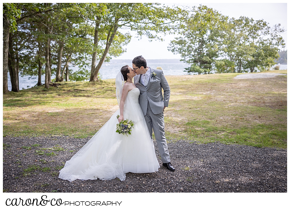 a bride and groom share a kiss at Barrett Park in Boothbay Harbor, Maine