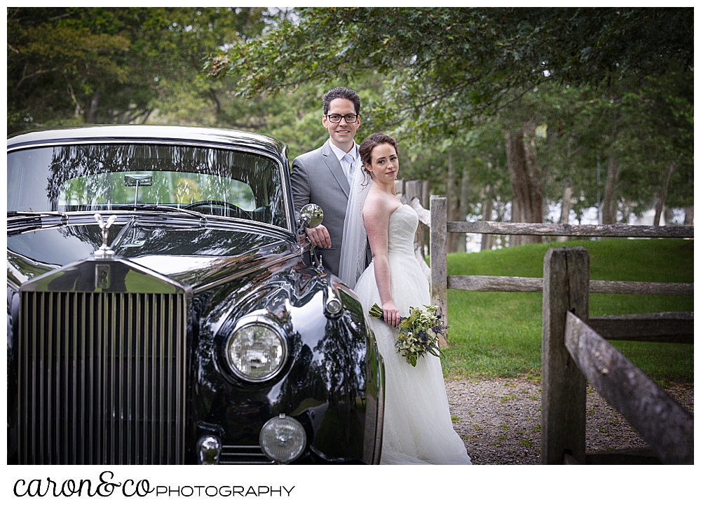 a bride and groom stand beside an antique Bentley