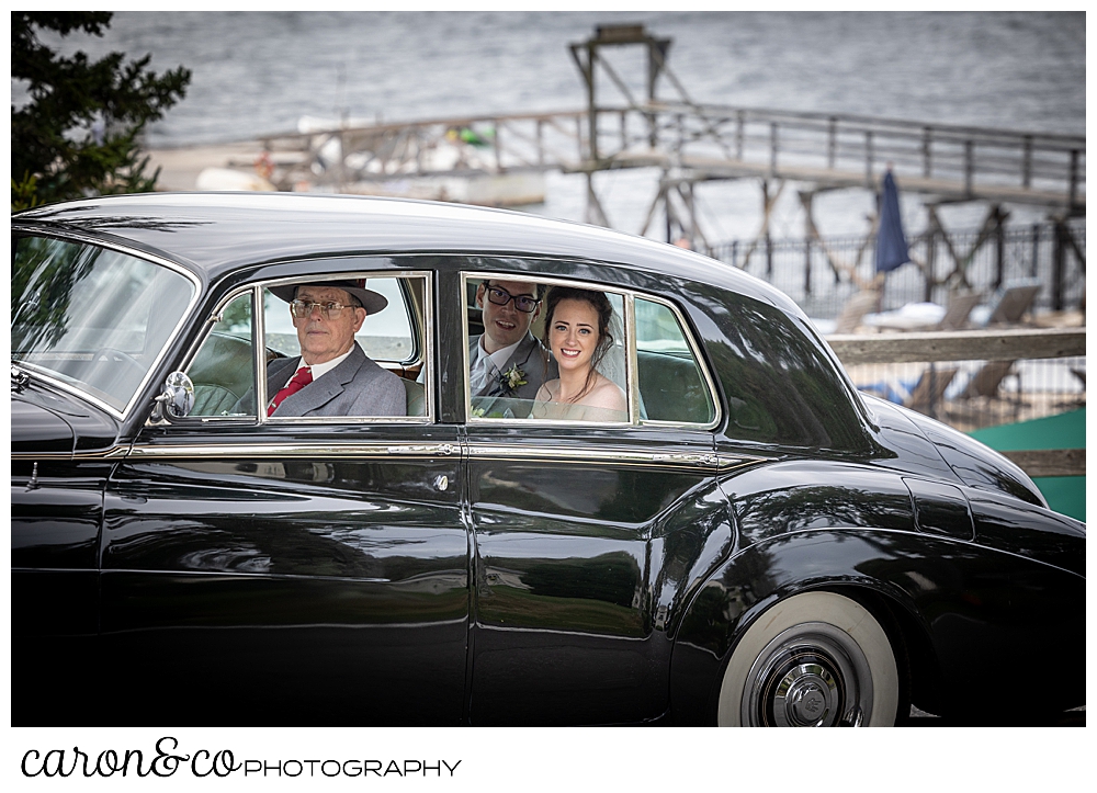 a bride and groom in the back of an antique Bentley, driven by the bride's grandfather, going to their Spruce Point Inn Maine wedding