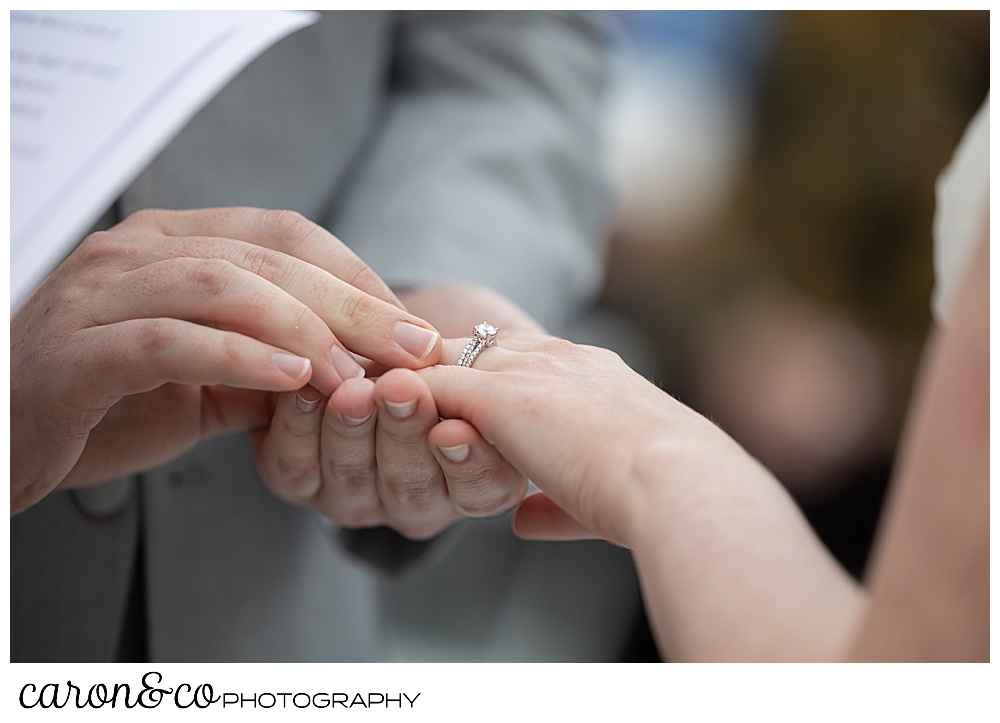 a groom places a wedding band on his bride