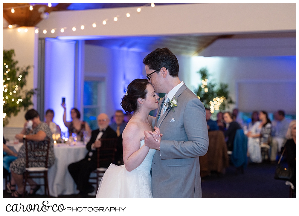 a bride and groom dance close during their first dance at their Spruce Point Inn Maine wedding reception