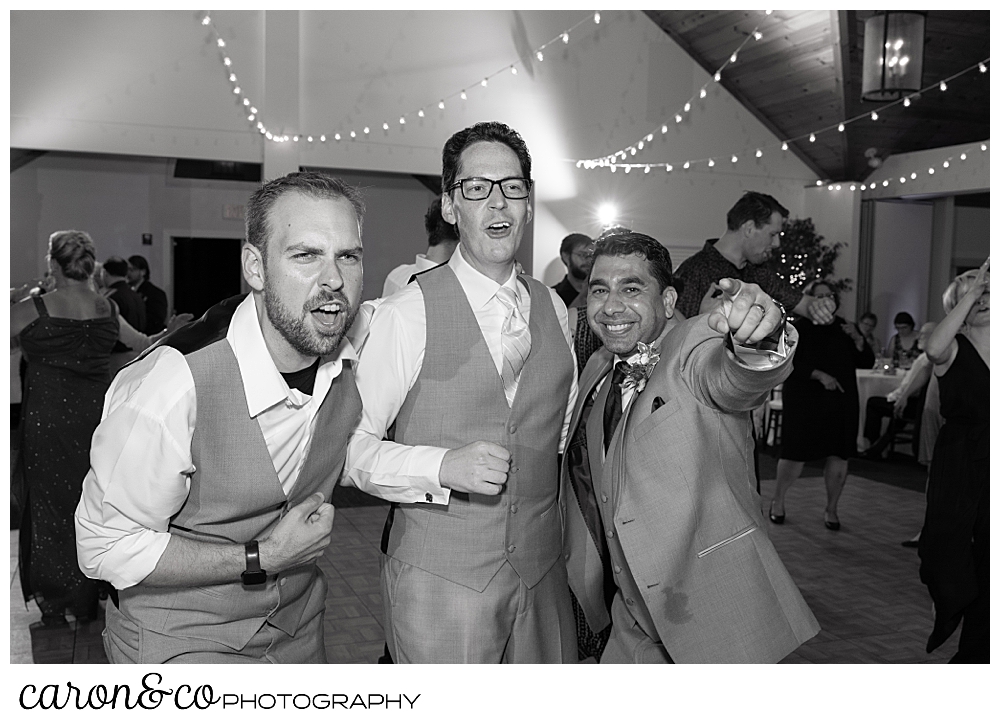 black and white photo of a groom and two of his groomsmen having fun on the dance floor at Spruce Point Inn, Boothbay Harbor, Maine